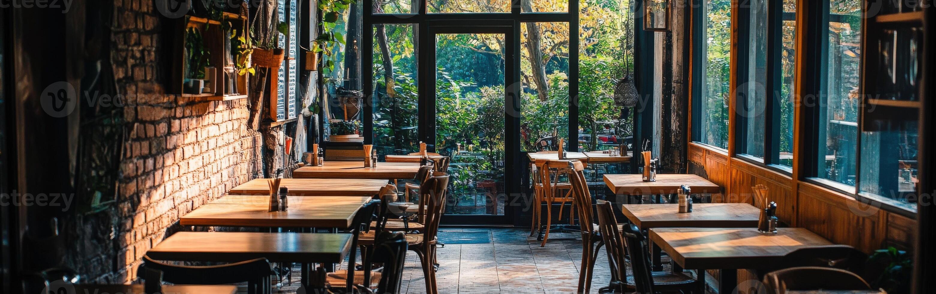 Cozy empty restaurant with wooden tables and large windows in the evening photo