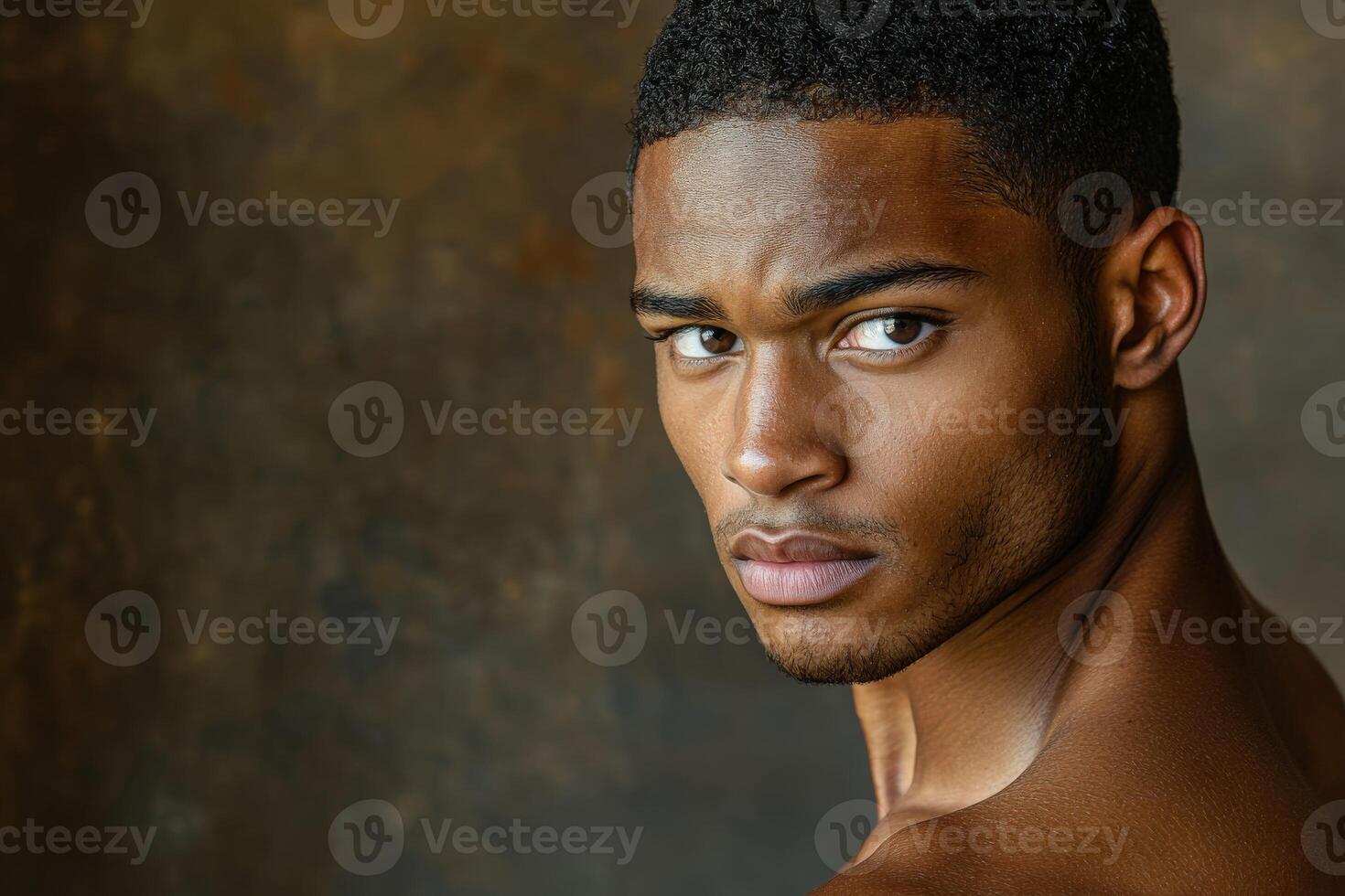 Athletic man poses for a striking portrait against a dark background photo
