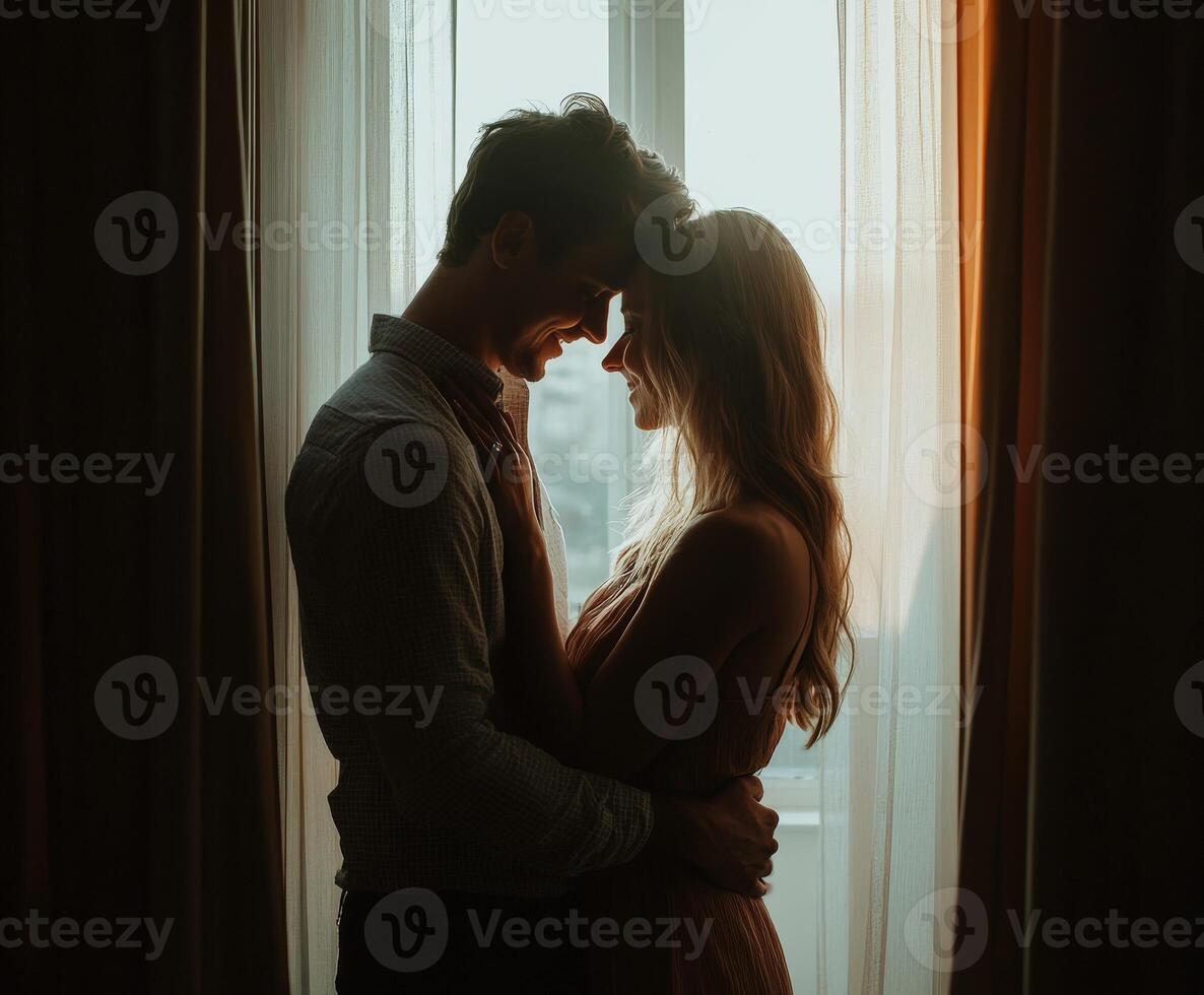 Silhouette of a couple sharing a tender moment by a sunlit window photo