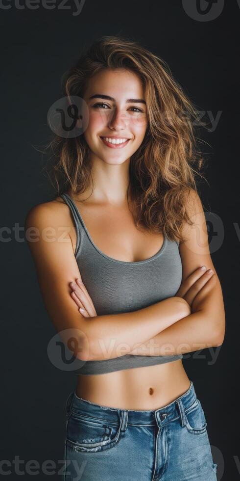 Young woman smiling confidently with crossed arms in natural lighting photo