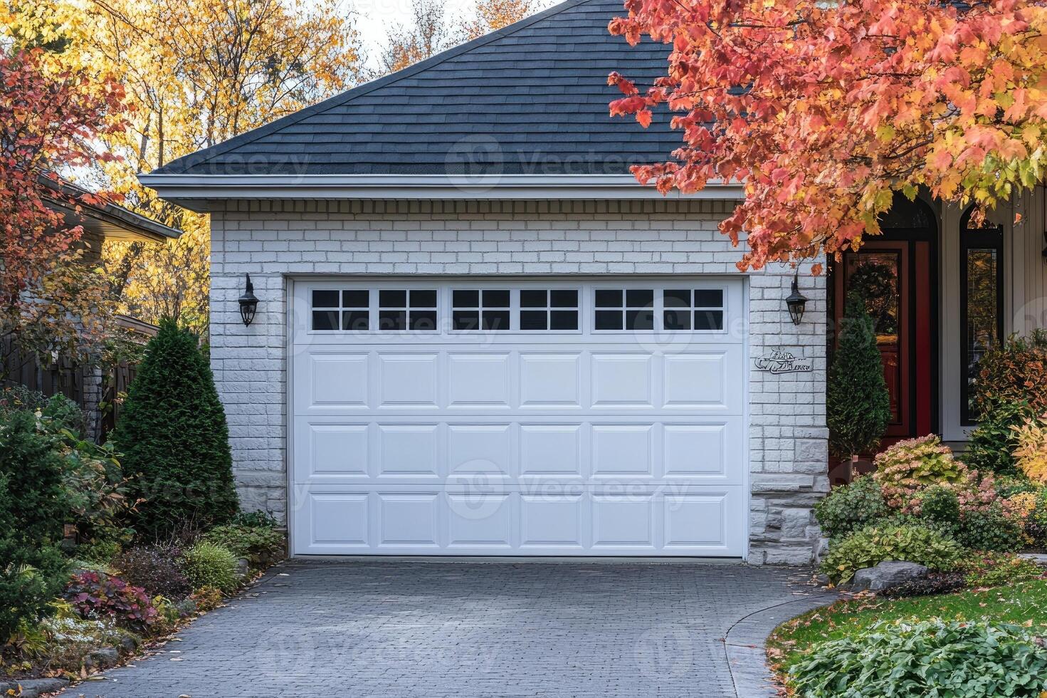 White garage door of a beautiful house surrounded by autumn colors photo