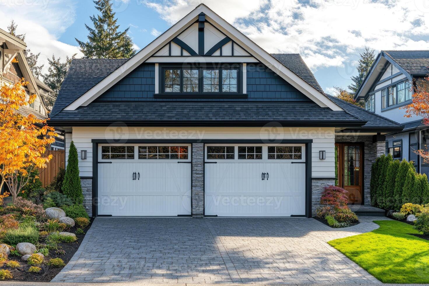 Beautiful residential home with white garage door and autumn foliage photo