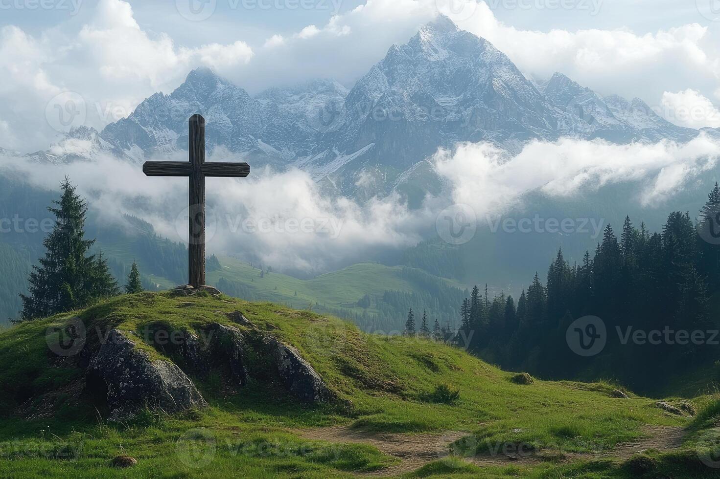 Wooden cross standing on a green hill with mountains in background photo