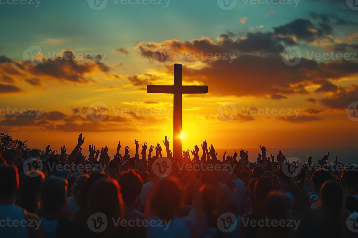 Crowd cheering at religious event at sunset with cross photo