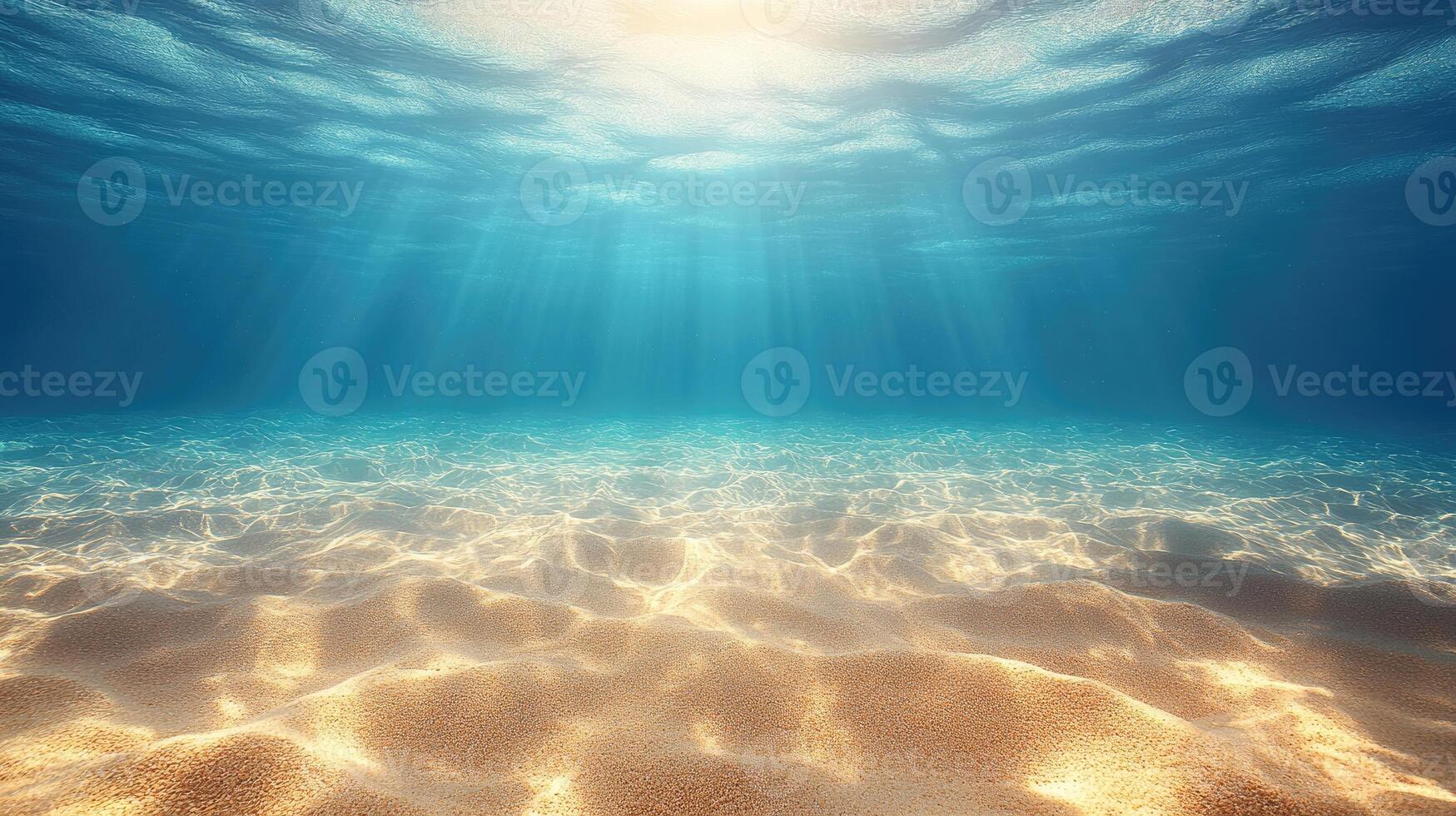 Sunlight shining through the surface of a clear ocean onto a sandy bottom photo
