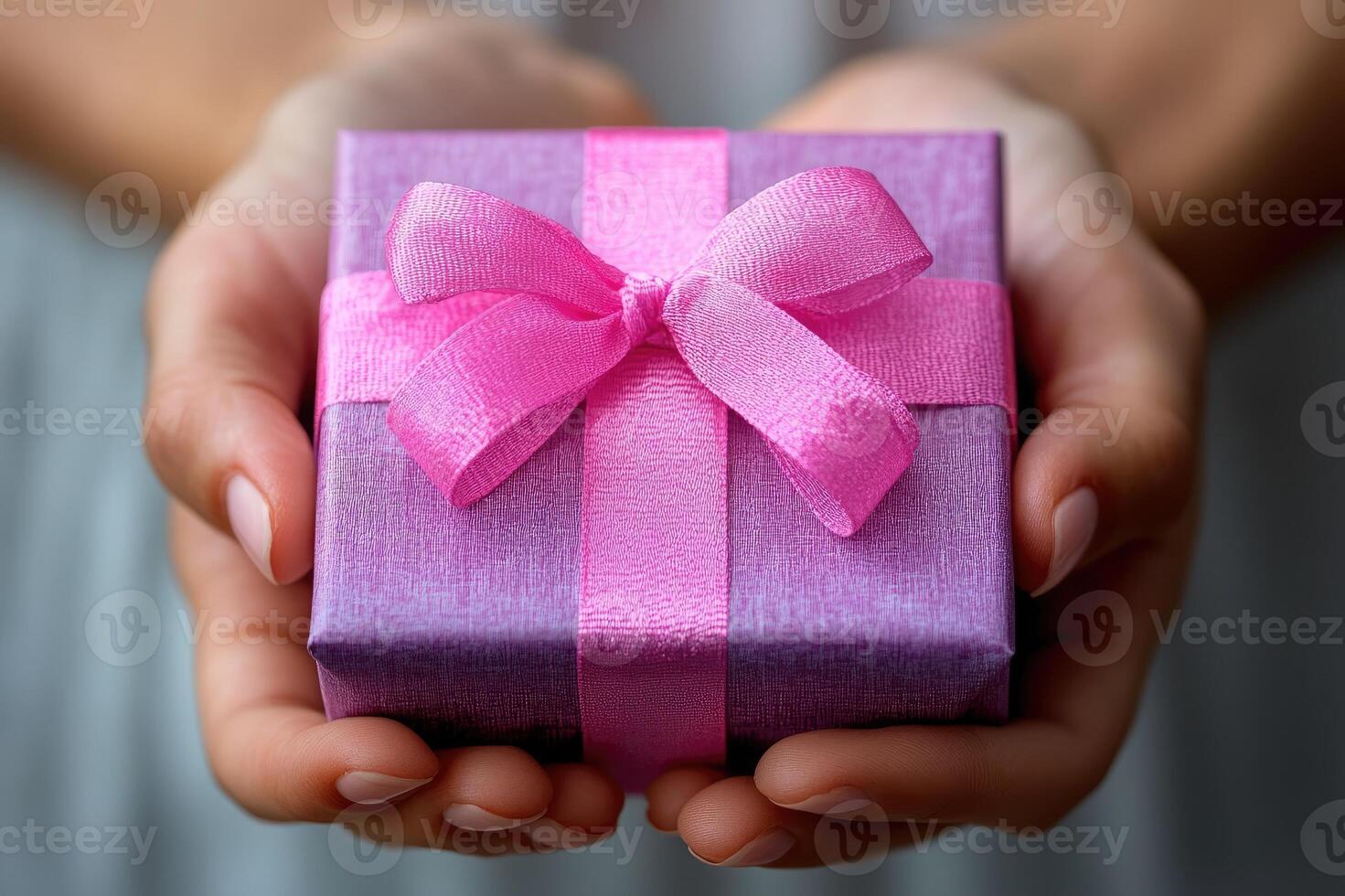 Woman holding a purple gift with pink ribbon photo