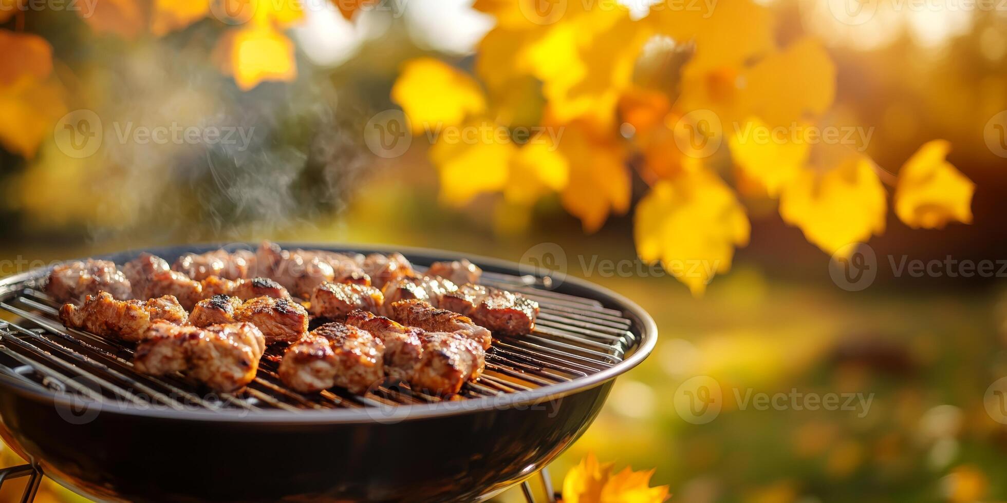Enjoy a beautiful and sunny autumn day while savoring delicious barbecue meat that is sizzling perfectly on the grill, all while being surrounded by the vibrant and colorful fall foliage all around photo