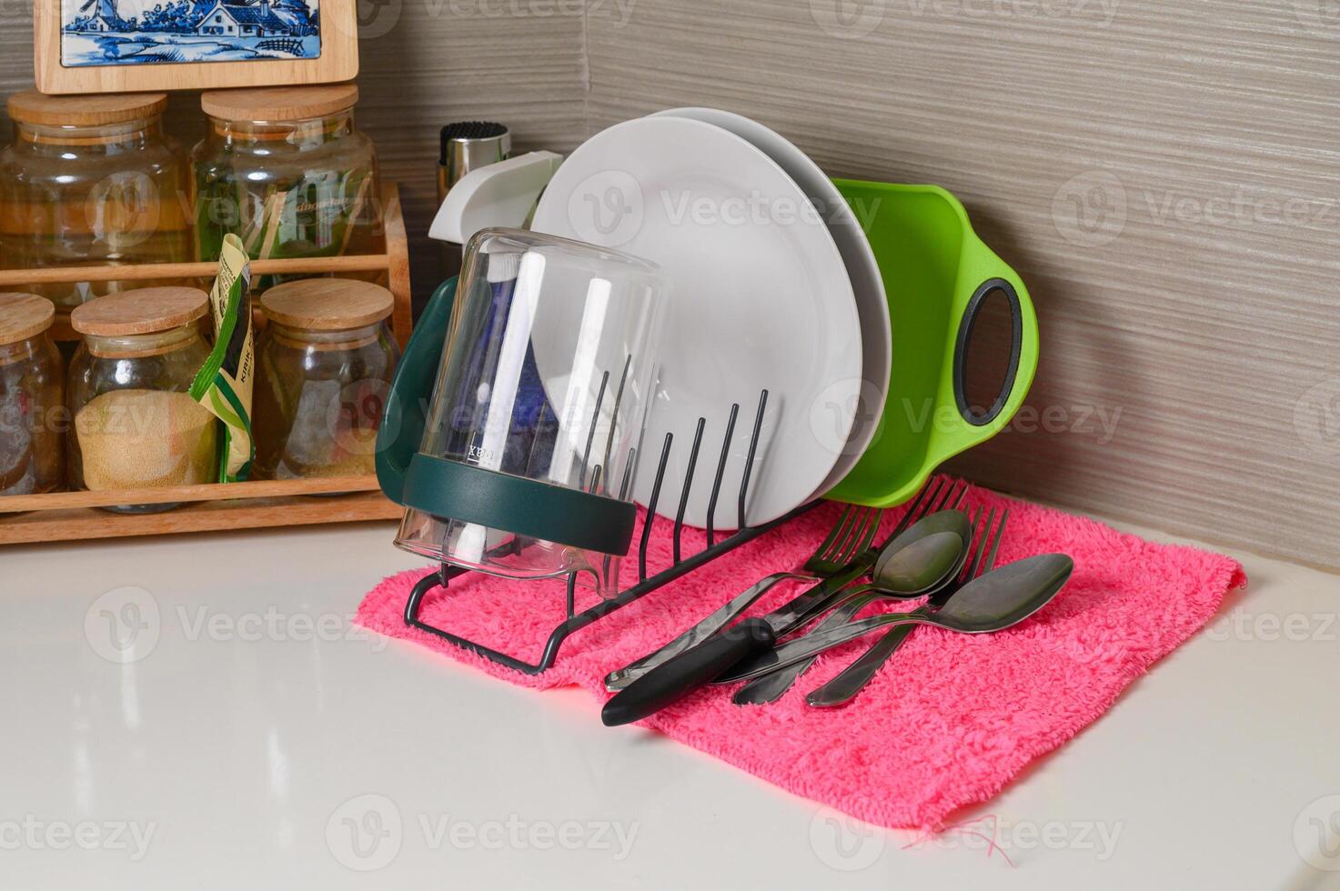 Drying rack with clean dishes on table in kitchen. Space for text photo