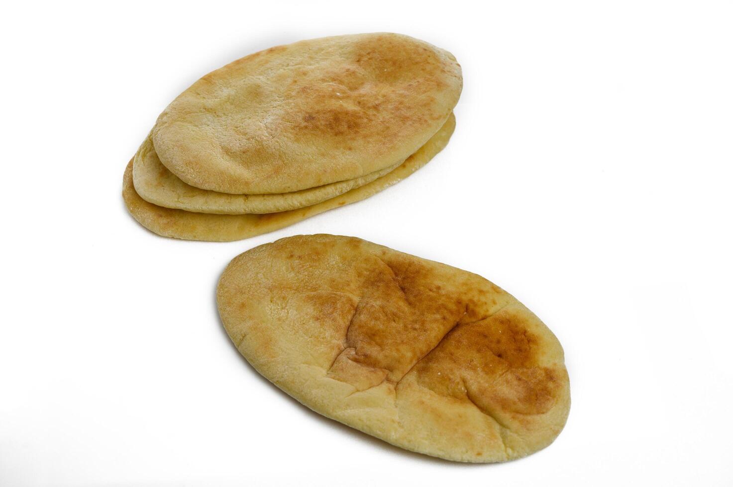 Loaves of delicious fresh pita bread on white background photo