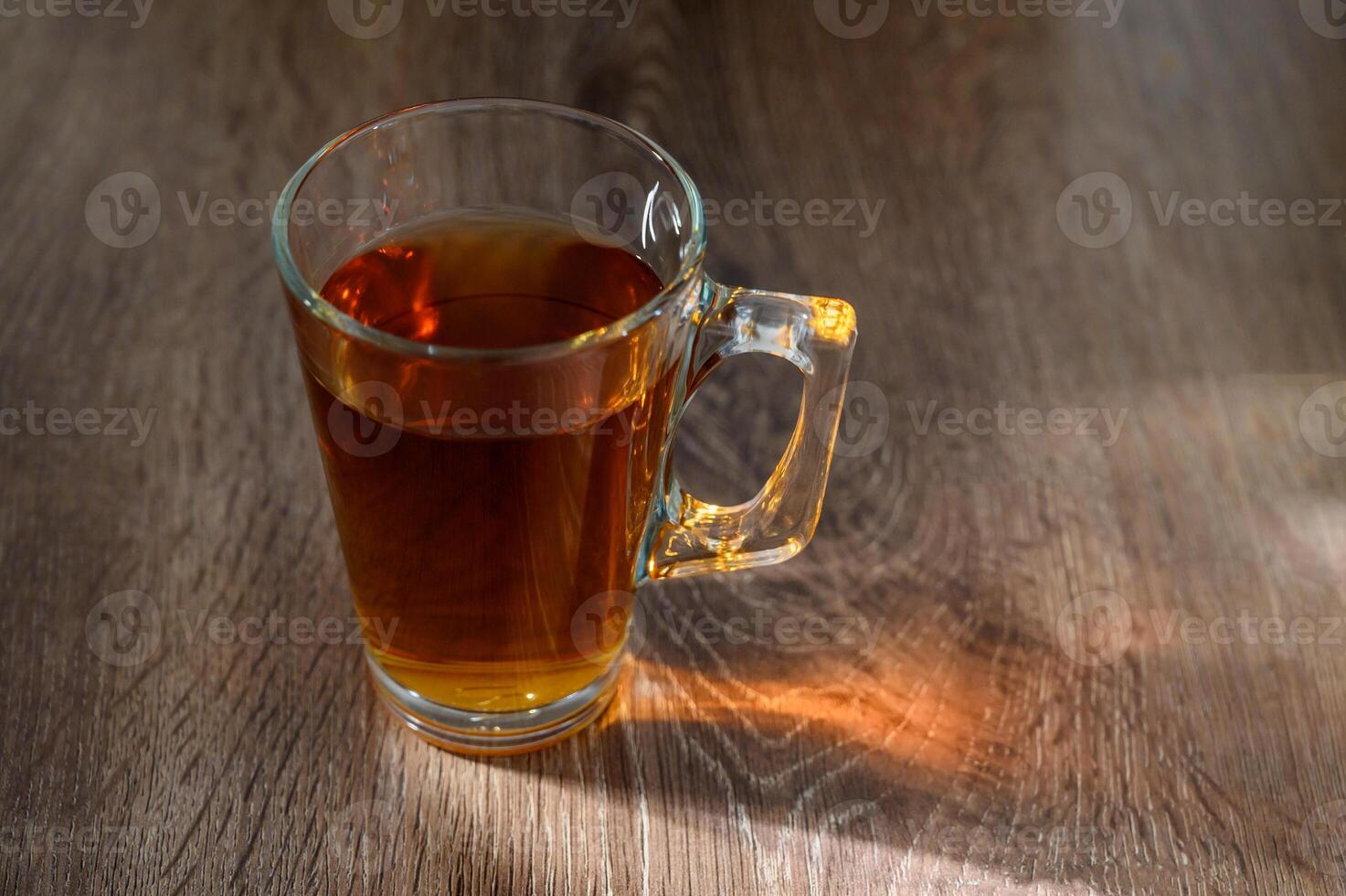 tea in glass cup on wooden table with bright, relaxing tea time concept photo