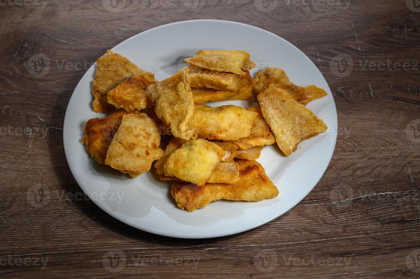 fillet of fish on white plate closeup on wooden background. photo
