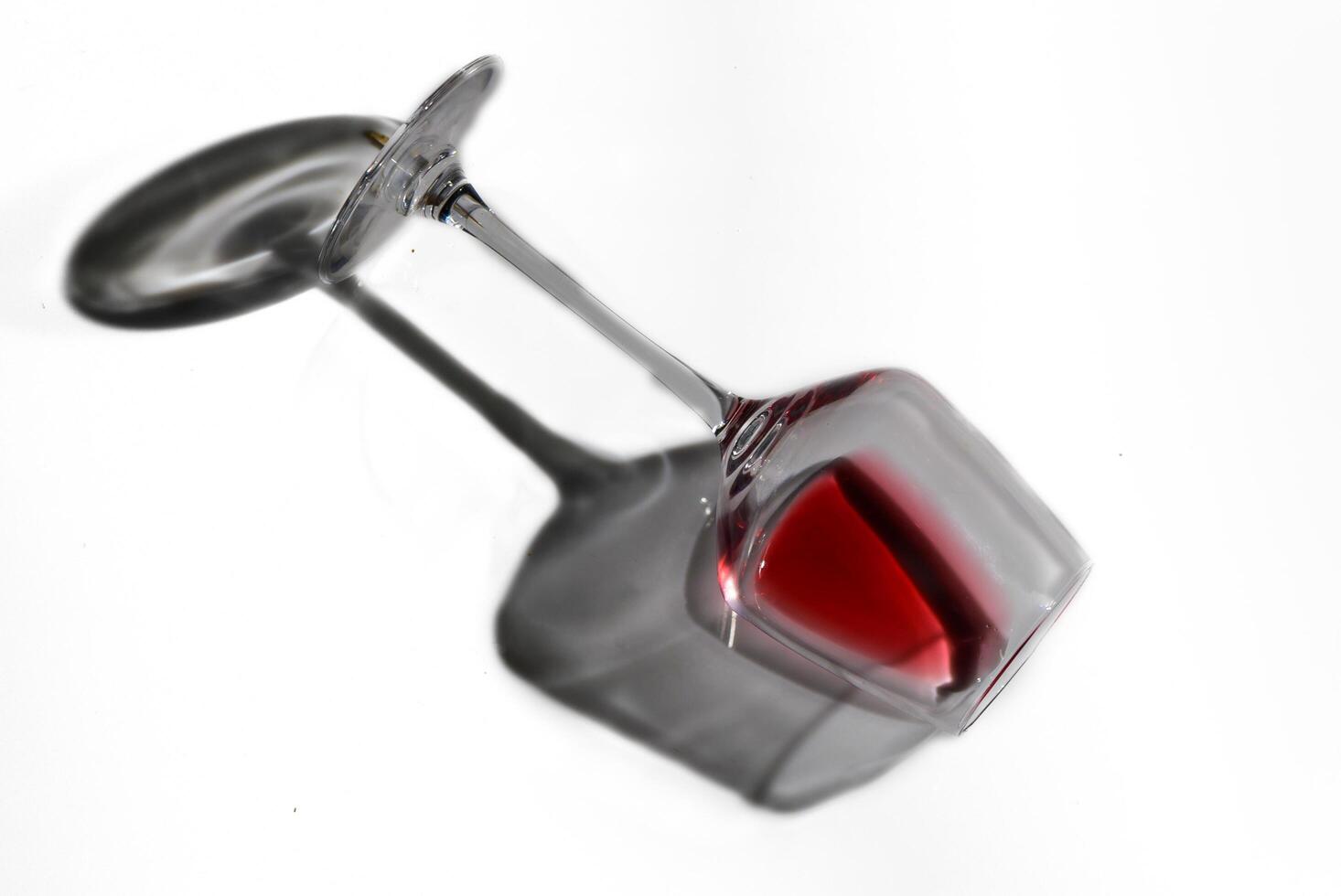 Red wine in laying glass on white background photo