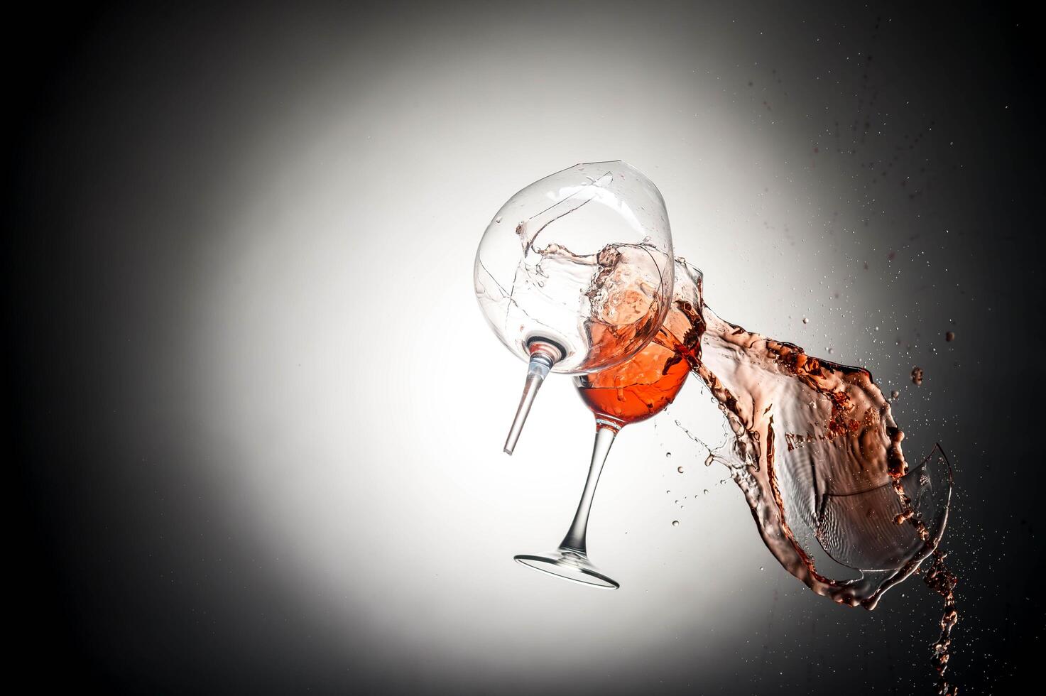 Collision of two wine glasses with splash photo
