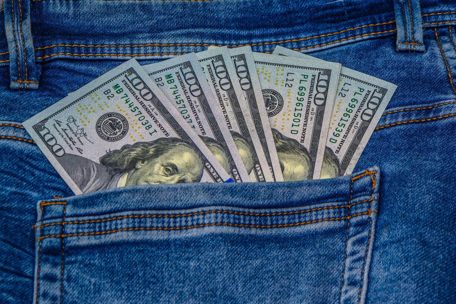 Money in pocket of blue jean on wooden background with copy space. photo
