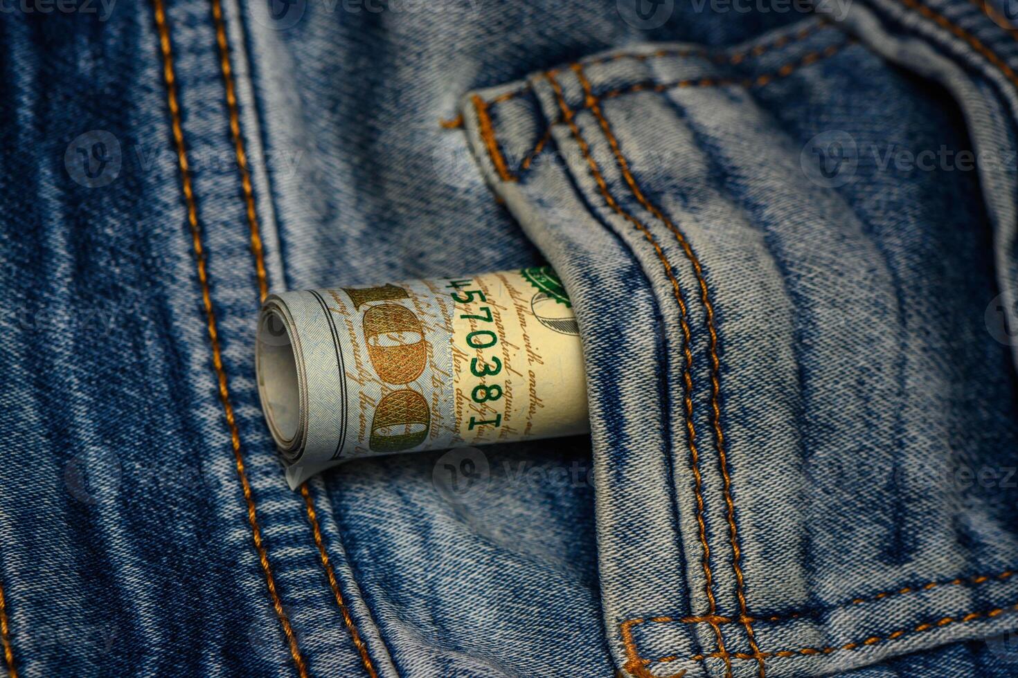 One hundred dollar banknote money in pocket jeans pants background texture. photo