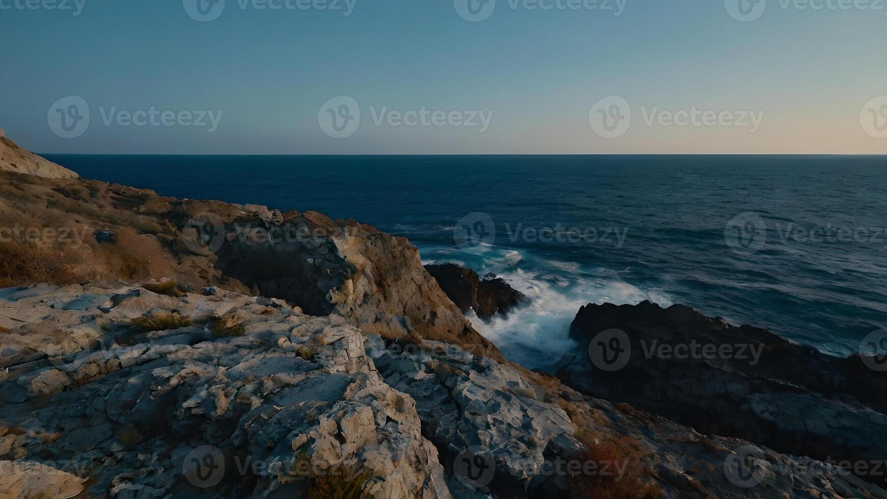 Rocky Coastline and Dramatic Ocean Waves at Sunset photo