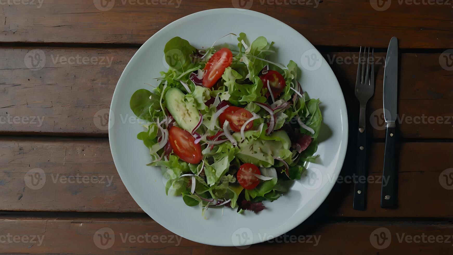 Fresh Salad on White Plate, Rustic Wooden Table with Silverware photo