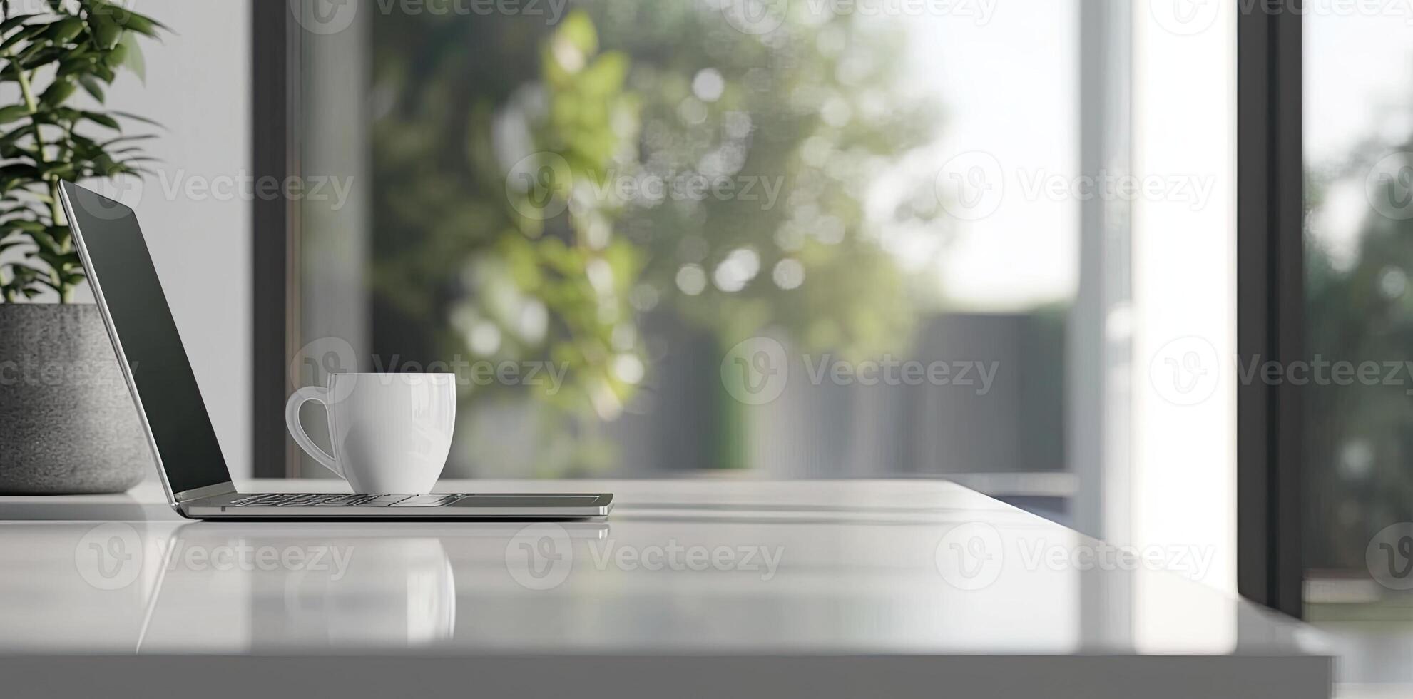 Blurred background of a modern home office interior with a laptop computer and a coffee cup on a white table, with copy space for text in the blurred window view. Business work from home concep photo