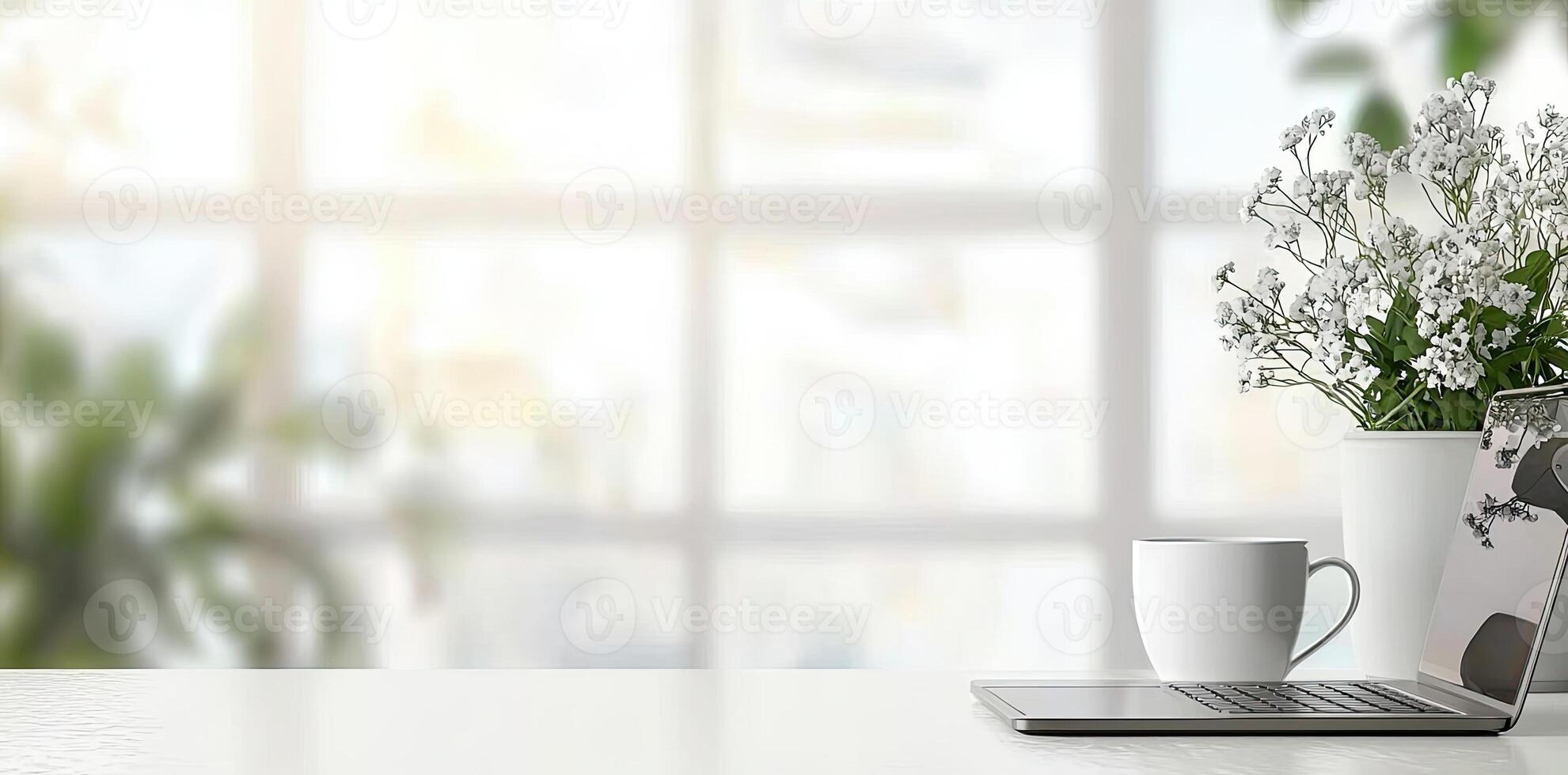 Blurred background of a modern home office interior with a laptop computer and a coffee cup on a white table, with copy space for text in the blurred window view. Business work from home concep photo