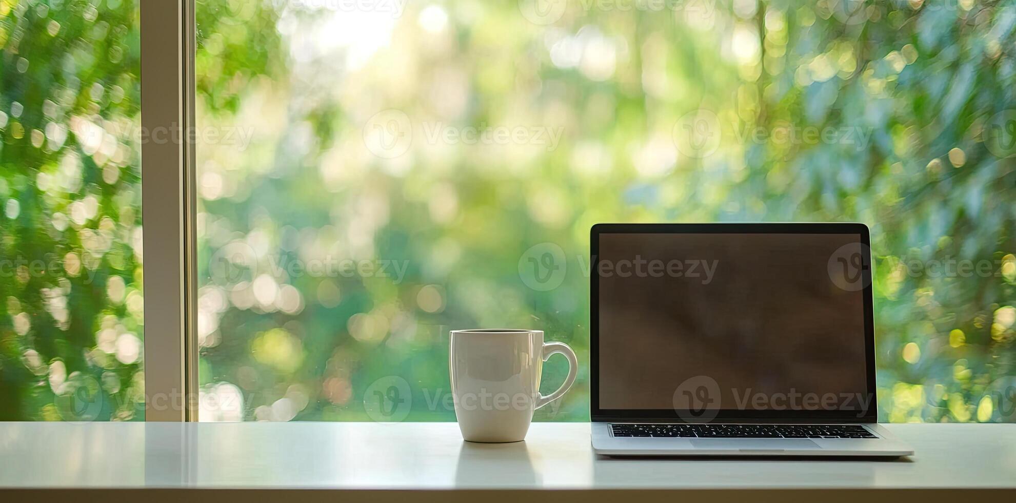 Blurred background of a modern home office interior with a laptop computer and a coffee cup on a white table, with copy space for text in the blurred window view. Business work from home concep photo