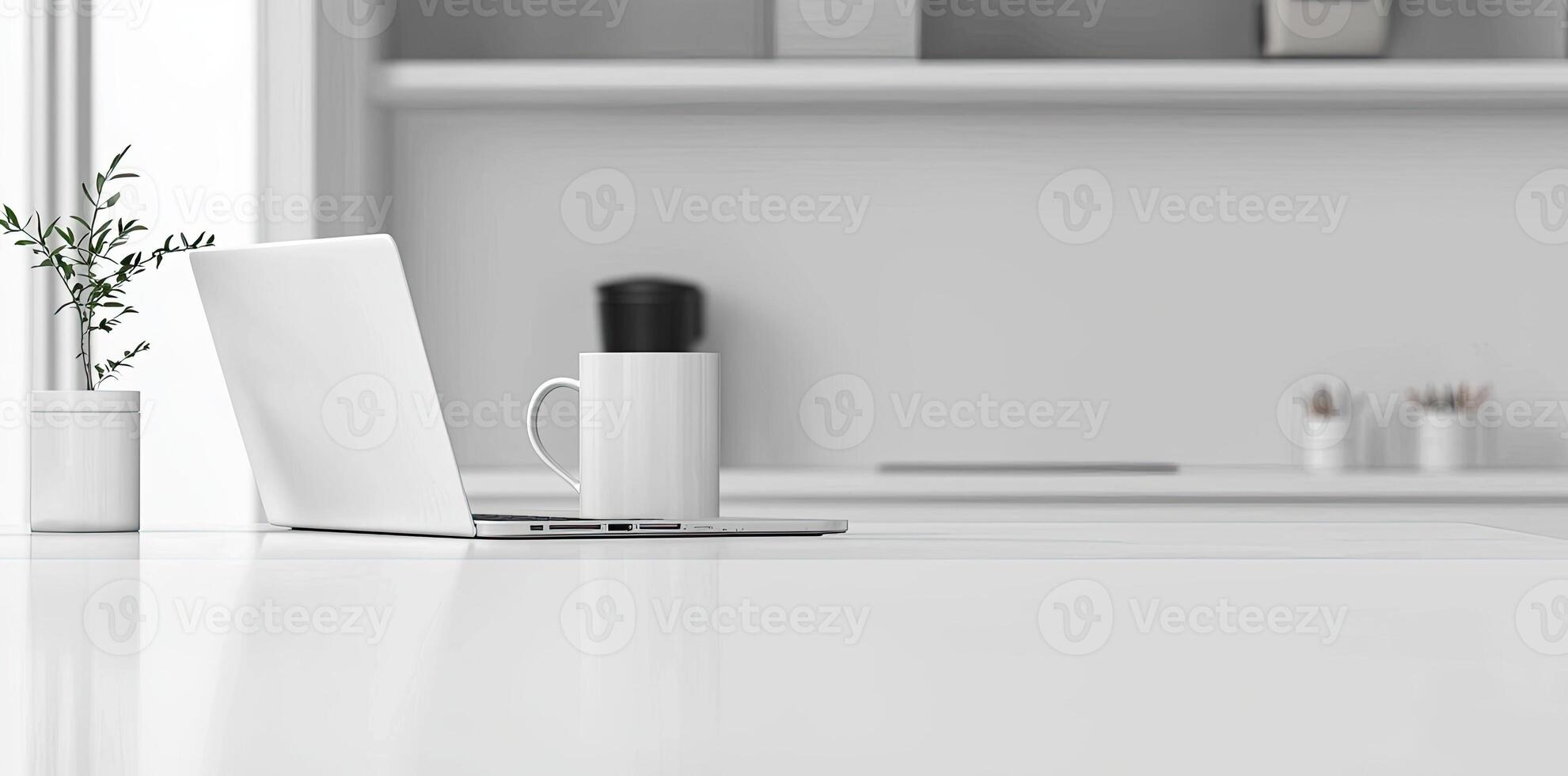 Minimalist white office desk with laptop and coffee mug on a blurred background, with space for text, representing the concept of working from home photo