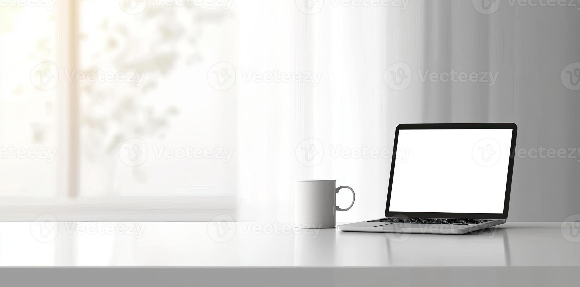 Minimalist white office desk with laptop and coffee mug on a blurred background, with space for text, representing the concept of working from home photo