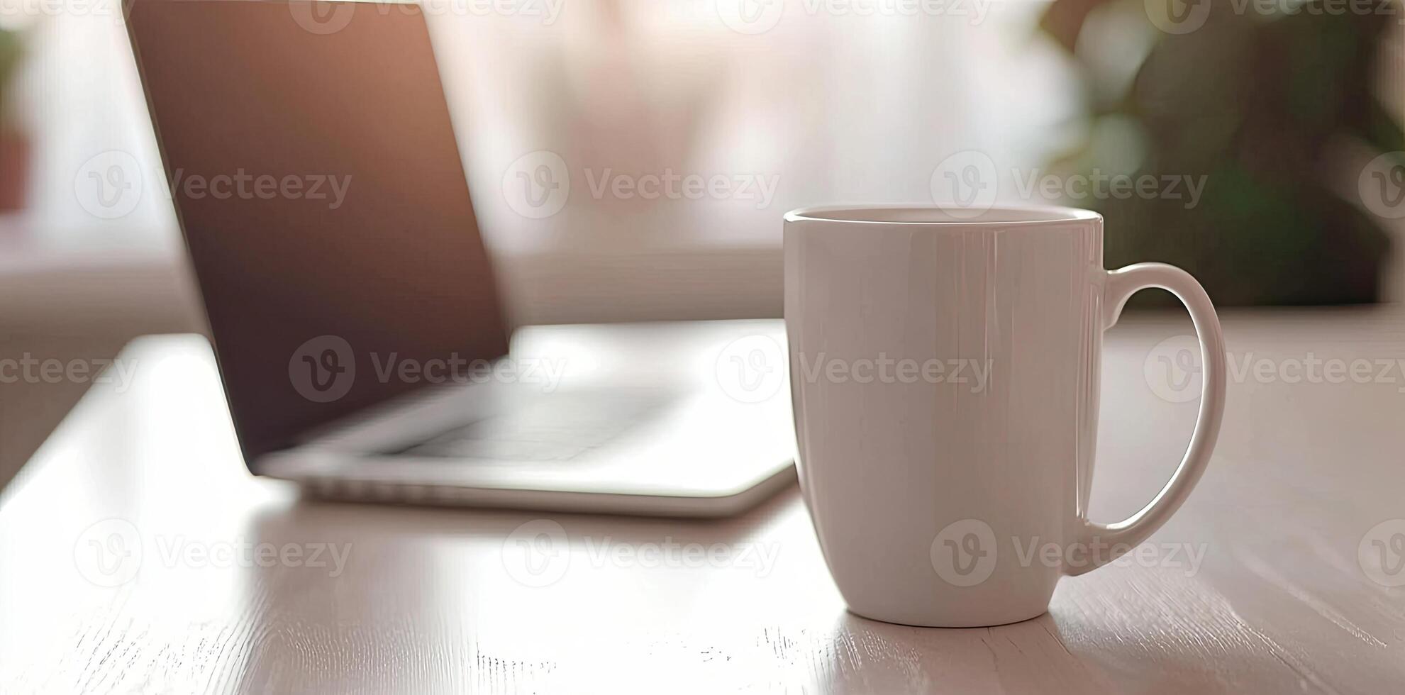 Minimalist white office desk with laptop and coffee mug on a blurred background, with space for text, representing the concept of working from home photo