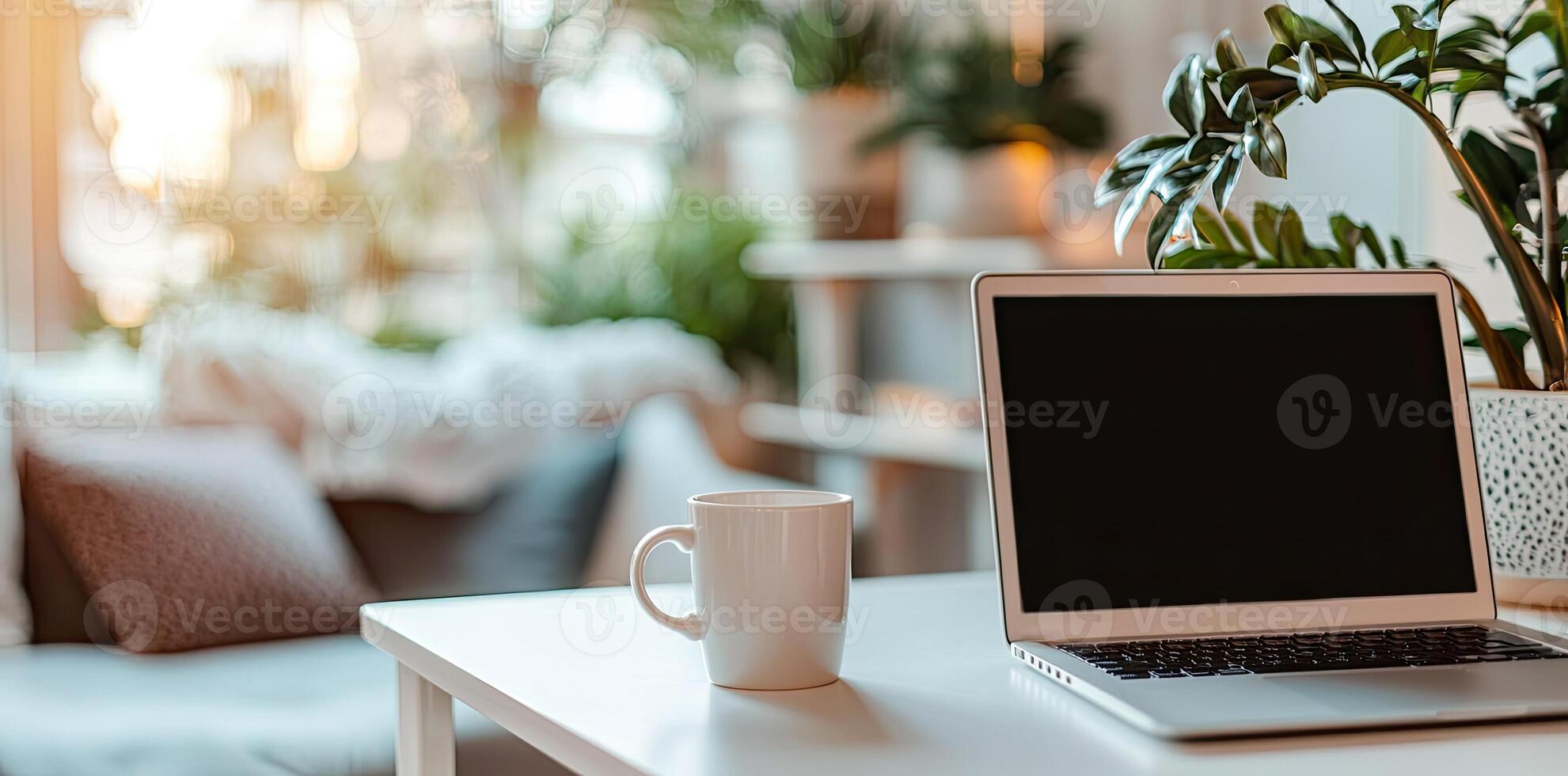 Minimalist white office desk with laptop and coffee mug on a blurred background, with space for text, representing the concept of working from home photo