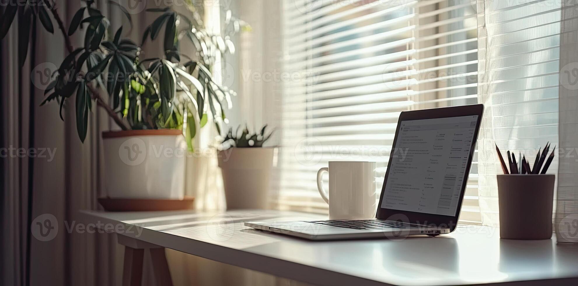 Minimalist white office desk with laptop and coffee mug on a blurred background, with space for text, representing the concept of working from home photo