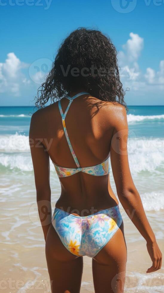 Model in a Beautiful Tropical Bikini Posing by the Glorious Sea. Enjoy a Serene Beach Day photo