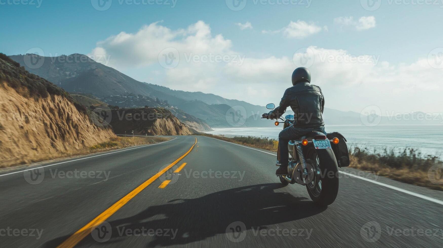 Motorcyclist cruising along coastal highway. A biker enjoying a solitary ride on a coastal road photo