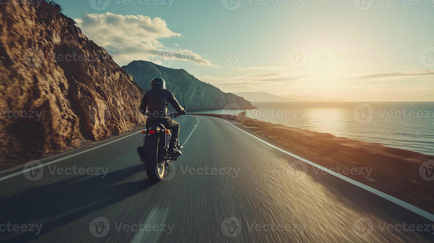 Motorcyclist cruising along coastal highway. A biker enjoying a solitary ride on a coastal road photo