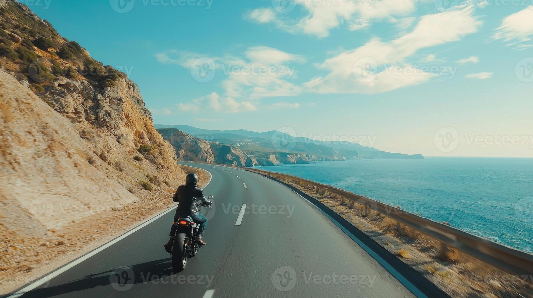 Motorcyclist cruising along coastal highway. A biker enjoying a solitary ride on a coastal road photo