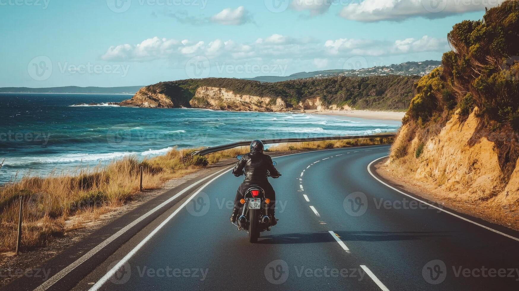 Motorcyclist cruising along coastal highway. A biker enjoying a solitary ride on a coastal road photo