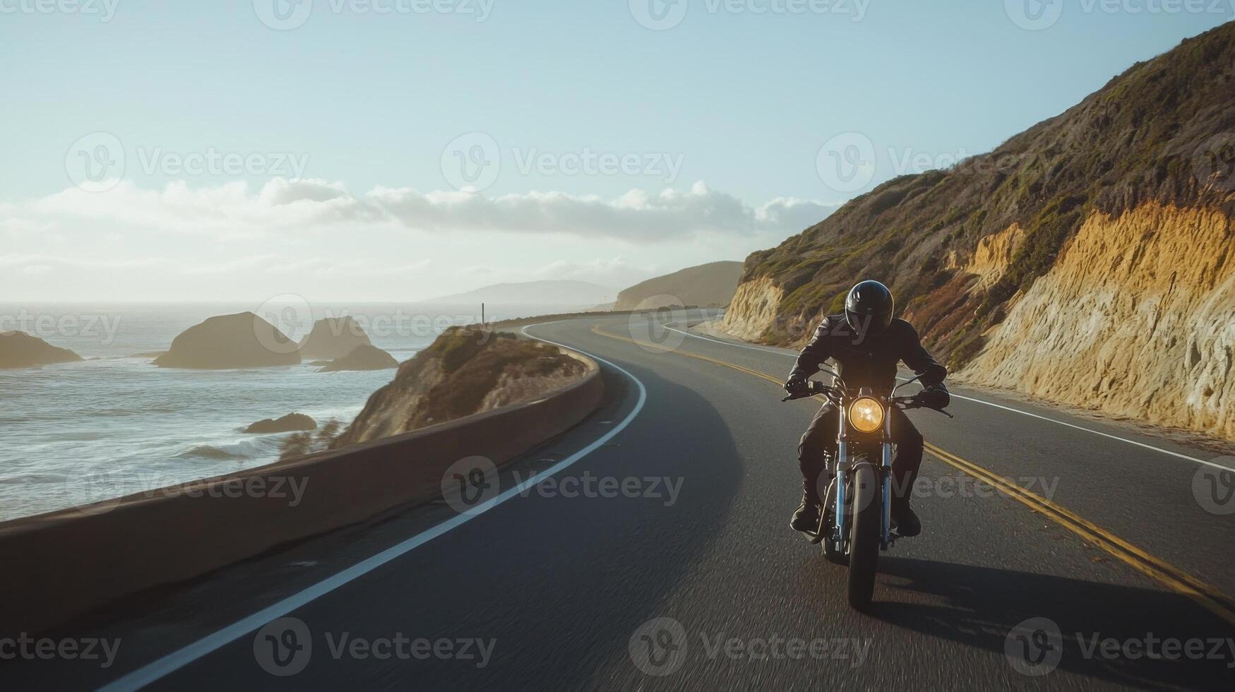 Motorcyclist cruising along coastal highway. A biker enjoying a solitary ride on a coastal road photo