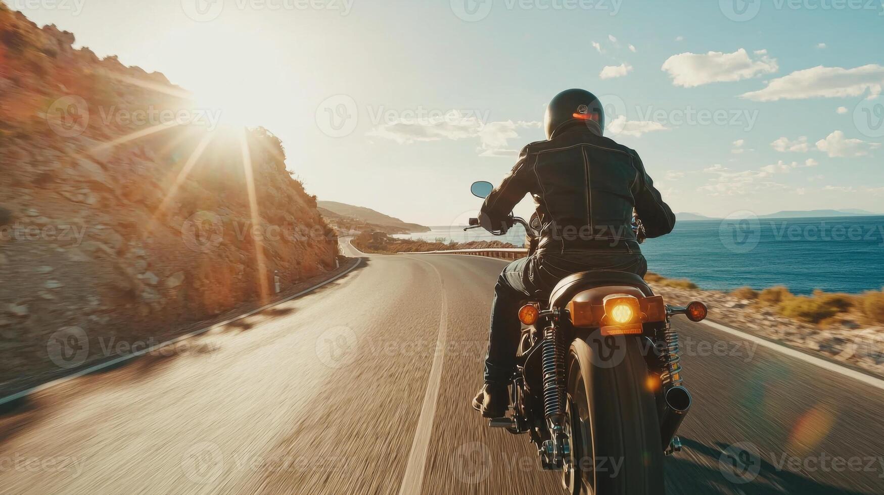 Motorcyclist cruising along coastal highway. A biker enjoying a solitary ride on a coastal road photo