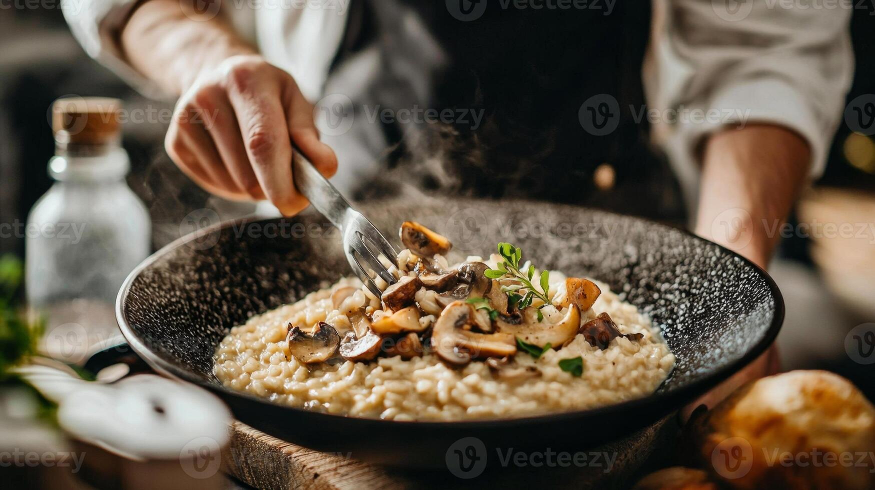 The chef prepares Risotto with mushrooms. Risotto with mushrooms is served in an elegant plate photo