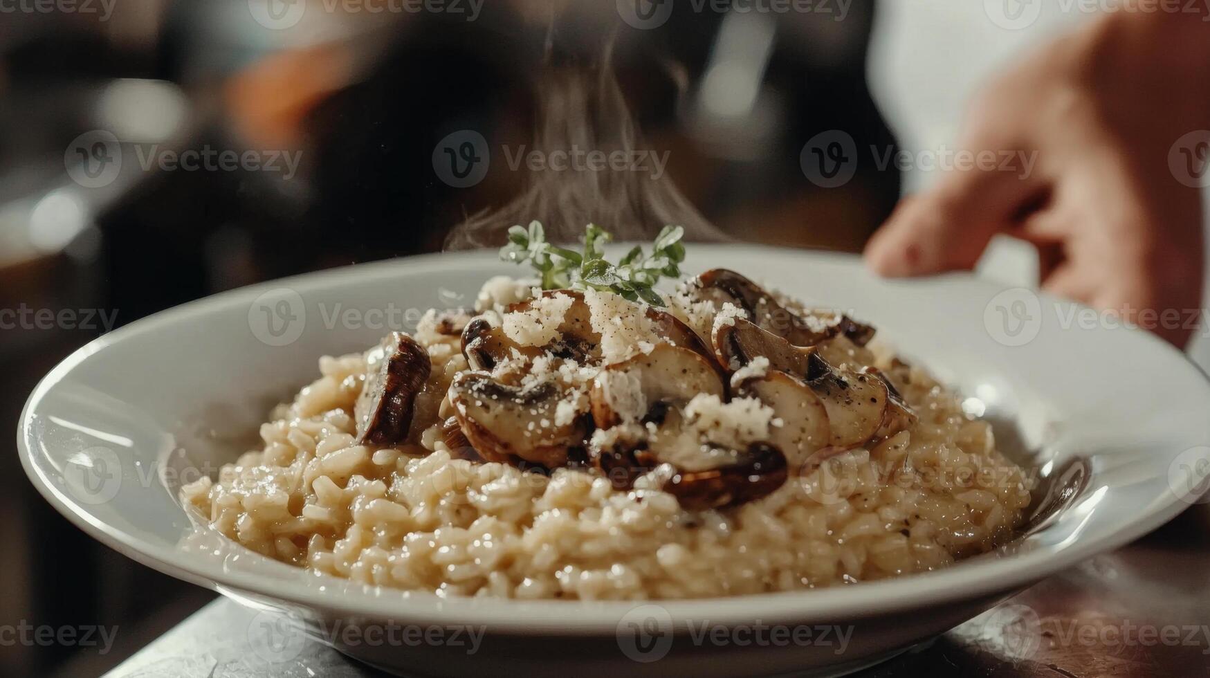 The chef prepares Risotto with mushrooms. Risotto with mushrooms is served in an elegant plate photo