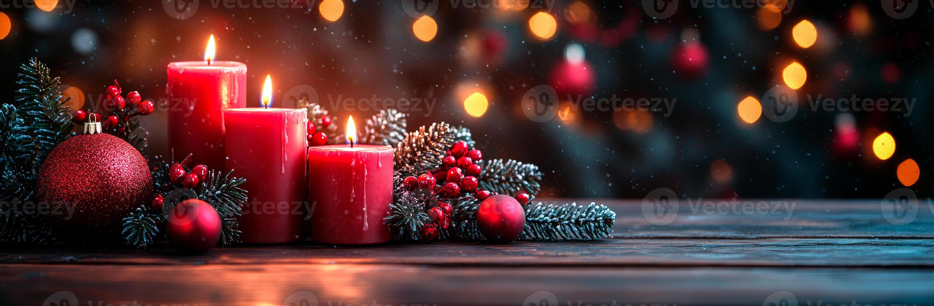 A Christmas tree with three red candles on it. The candles are lit and surrounded by red berries photo