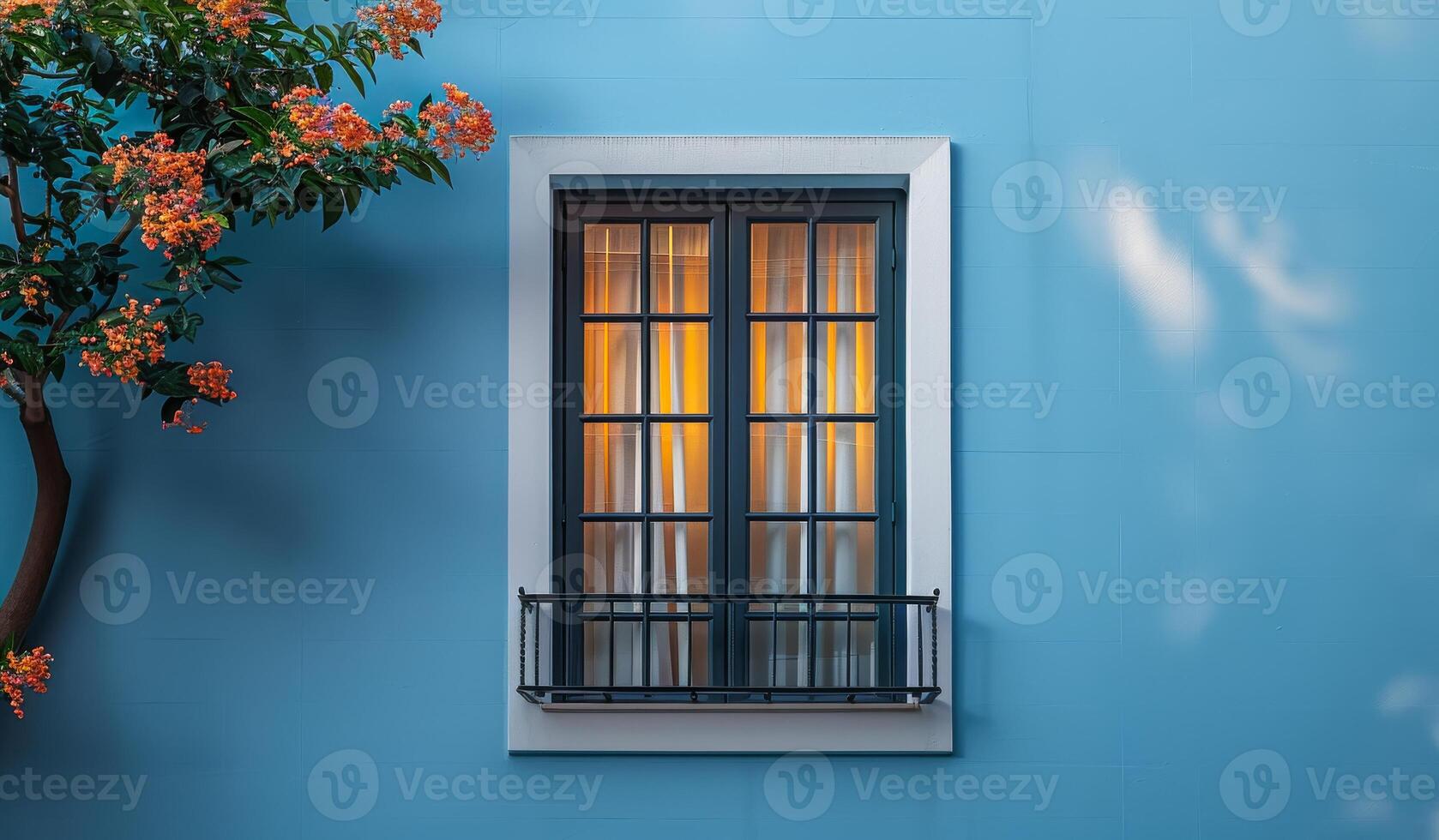 A window with a white curtain and a black frame. The window is open and the curtain is drawn. The window is in front of a wall with a blue color photo