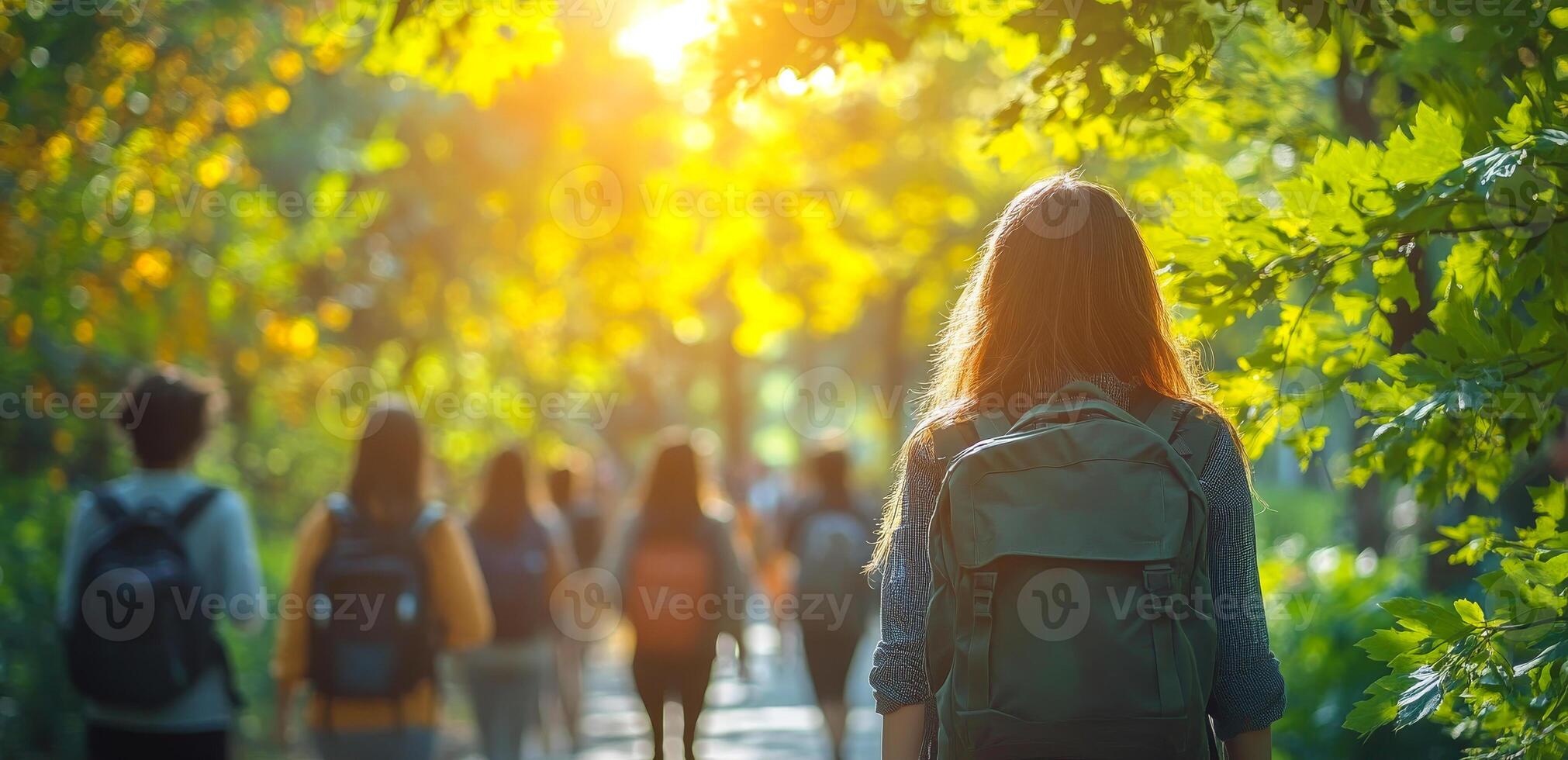 A group of people are walking in a forest, with one woman wearing a backpack. Scene is peaceful and serene, as the group of people are enjoying a walk in nature photo