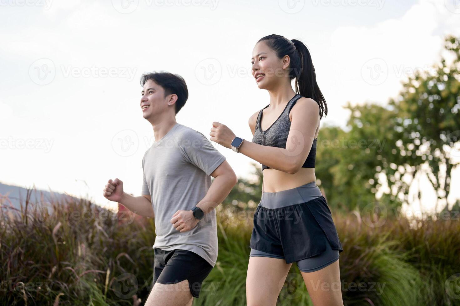 An active, sporty Asian couple in sportswear is enjoying a run together in a park in the morning. photo