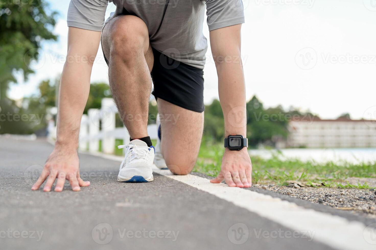 A cropped image of an active man in sportswear in a ready-to-run position, preparing to sprint. photo