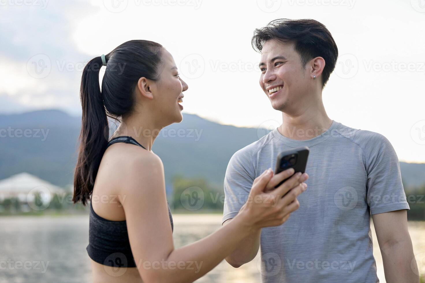 A couple is enjoying a conversation while resting together after their morning run in a park. photo