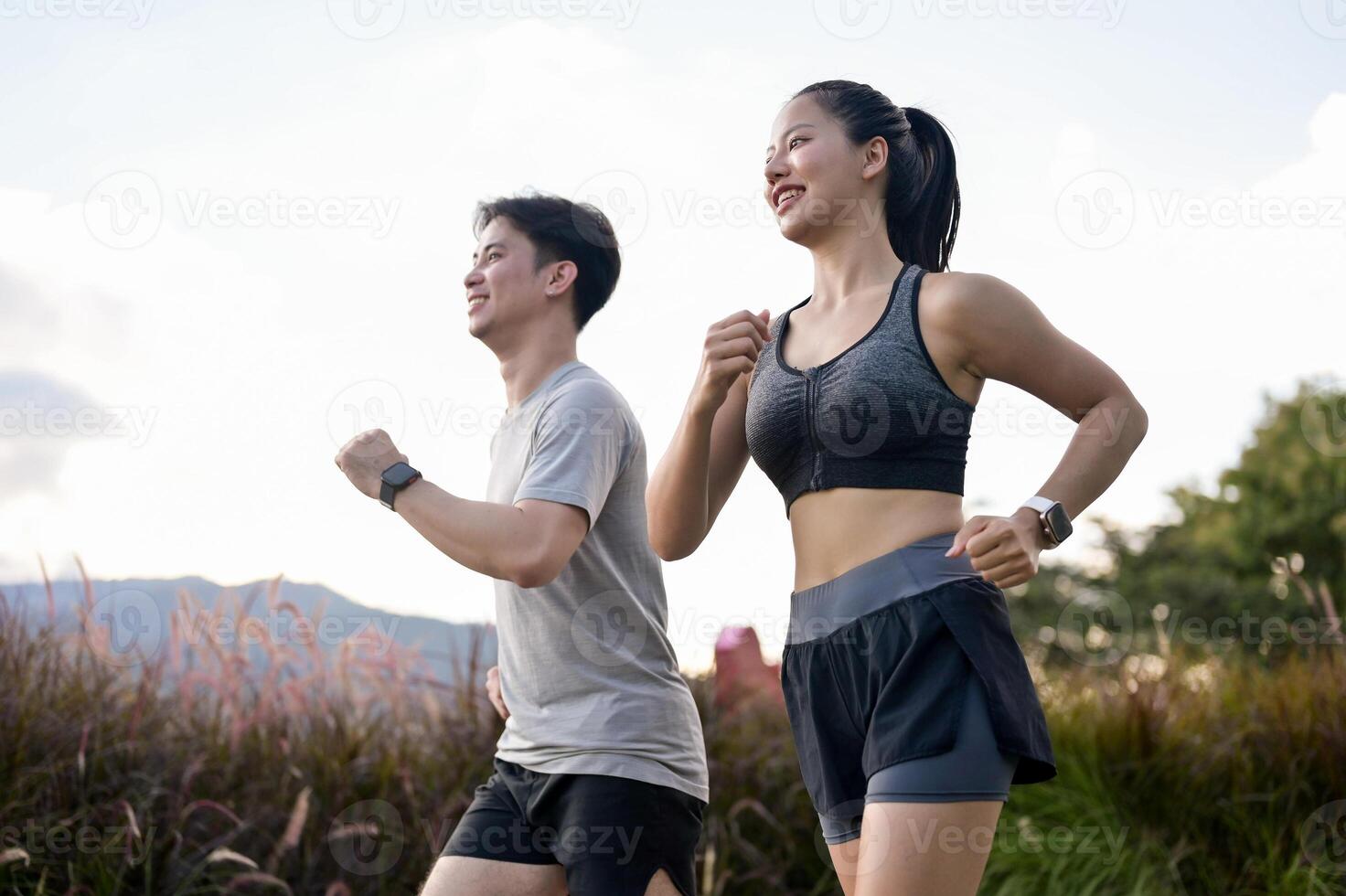An active, sporty Asian couple in sportswear is enjoying a run together in a park in the morning. photo