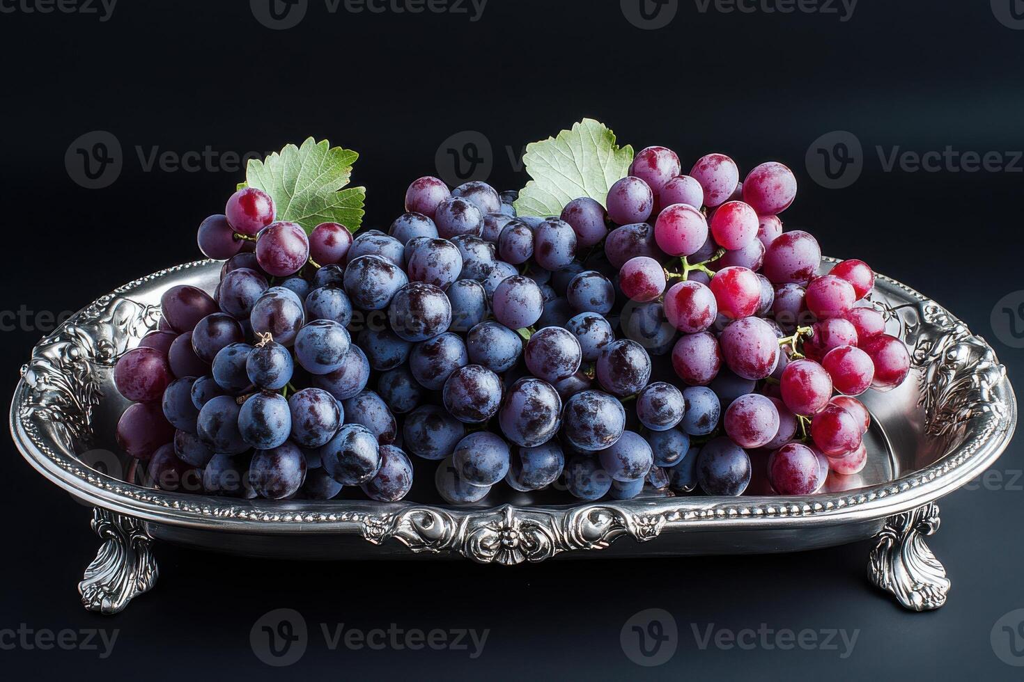 Fresh grapes placed elegantly on a silver platter against a dark background photo