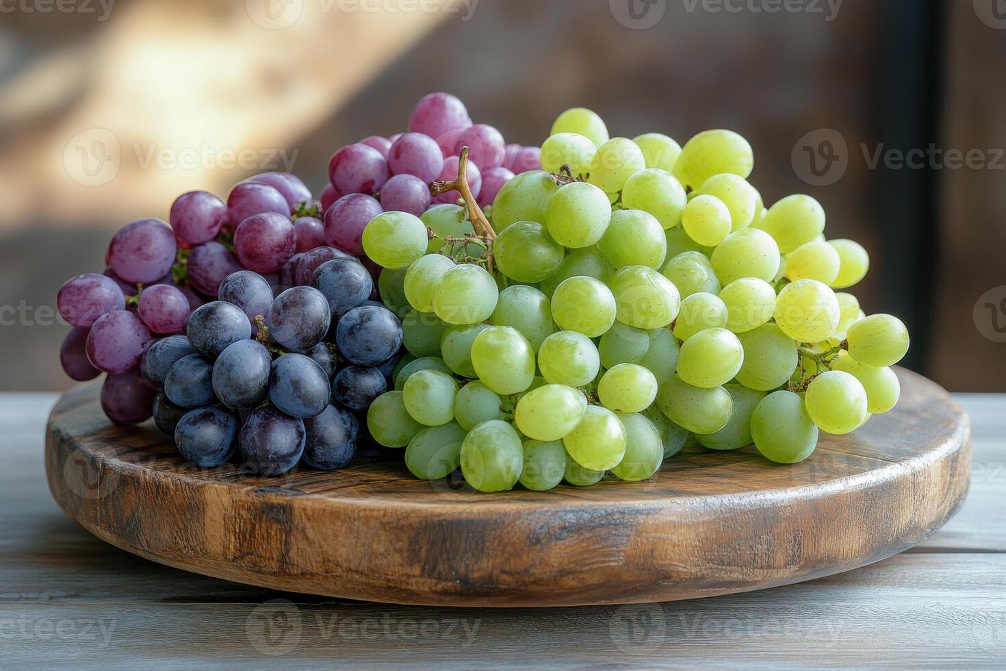 A vibrant selection of fresh grapes displayed on a wooden platter in natural light photo