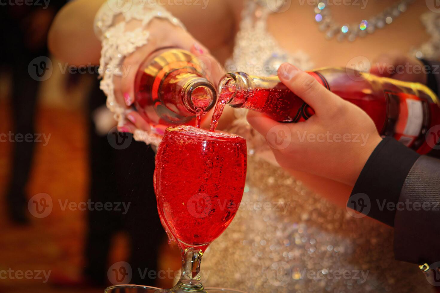 A man pouring a red liquid into a glass photo