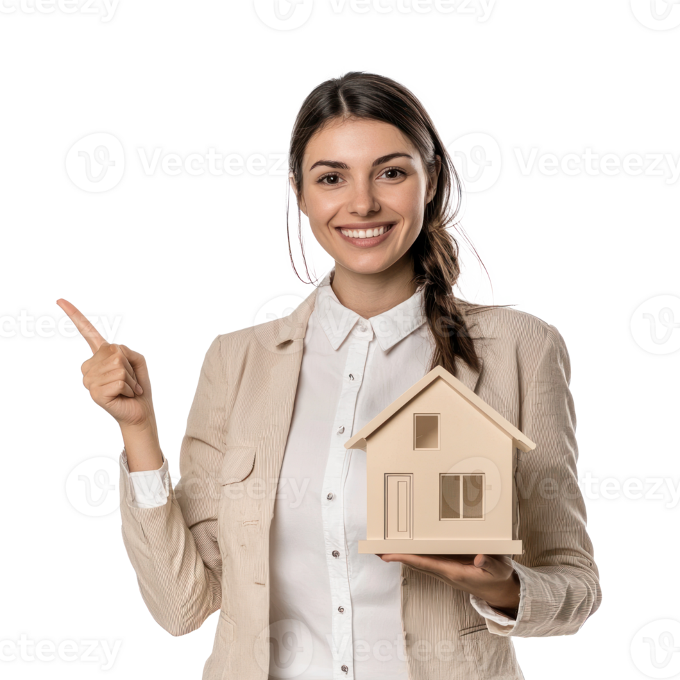Smiling young businesswoman holding house for mortgage with hand pointing at empty space front view isolate on transparent background png