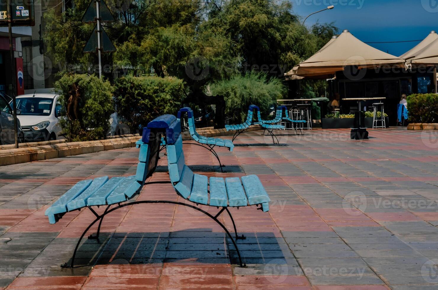 Blue Bench on a Seaside Street A Quiet Spot for Reflection photo